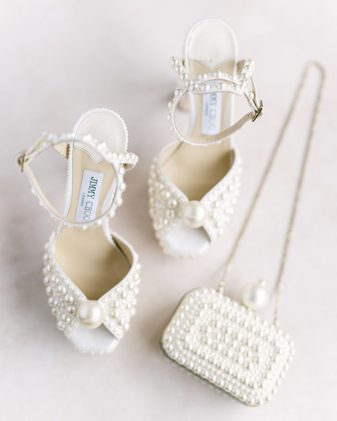 Detail of bride's Jimmy Choo shoes and handbag. Wedding photography by Heather Durham.