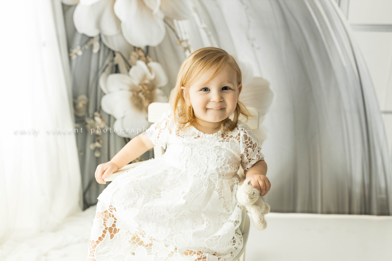 Girl wearing knitted dress posing in soft neutral white background portrait