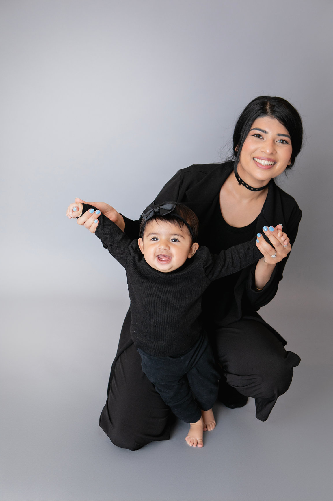 Mother holding her baby in coordinated black outfits
