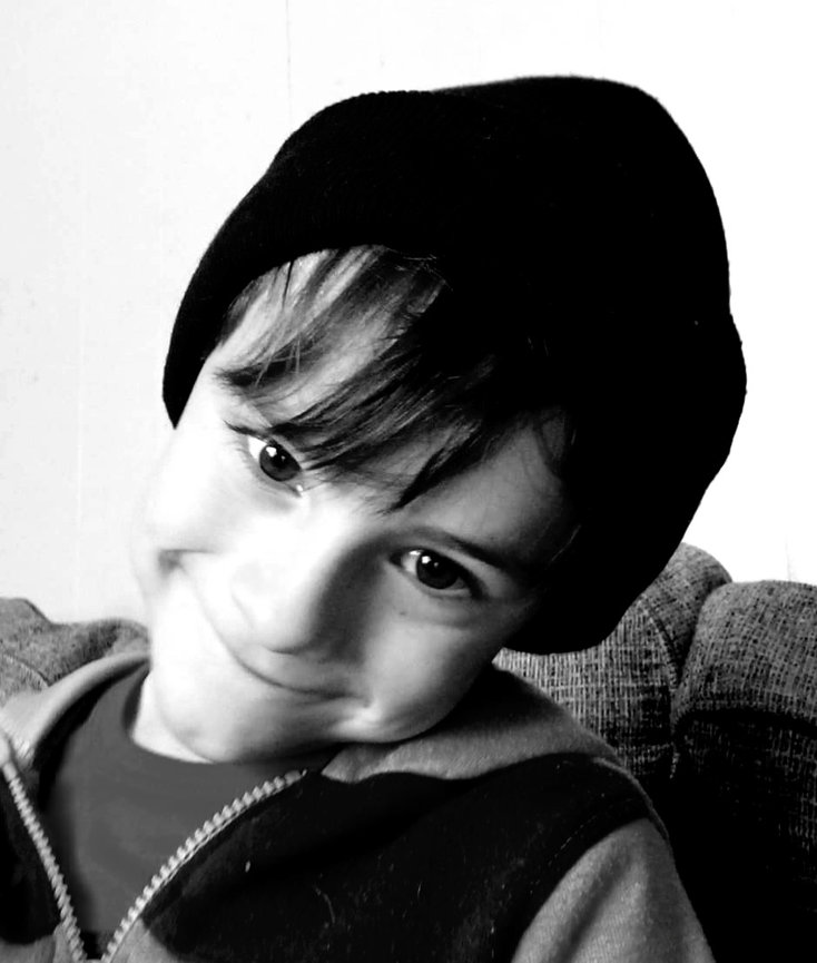 Black and white photo of a boy in a beanie