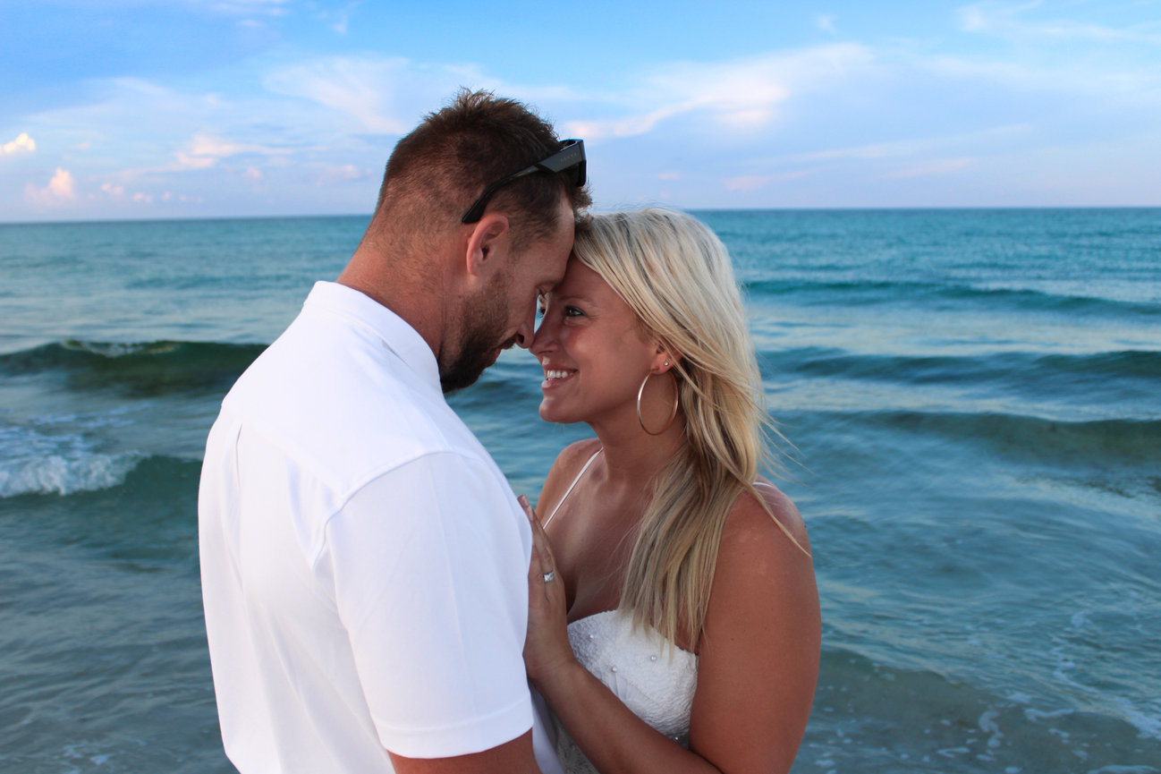 A couple embracing with the ocean in the background
