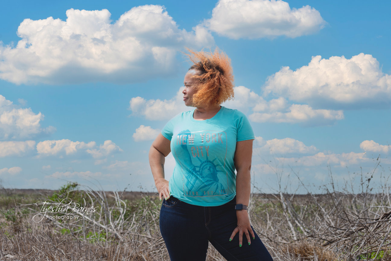 Portrait of photographer standing outdoors under a blue sky, reflecting a relaxed and approachable photography style