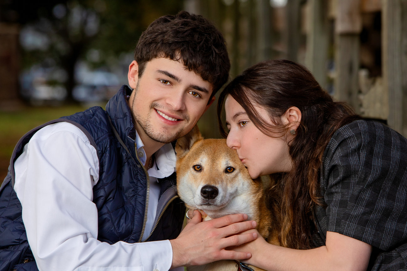 Photo of teens kissing their pet dog at the family ranch.