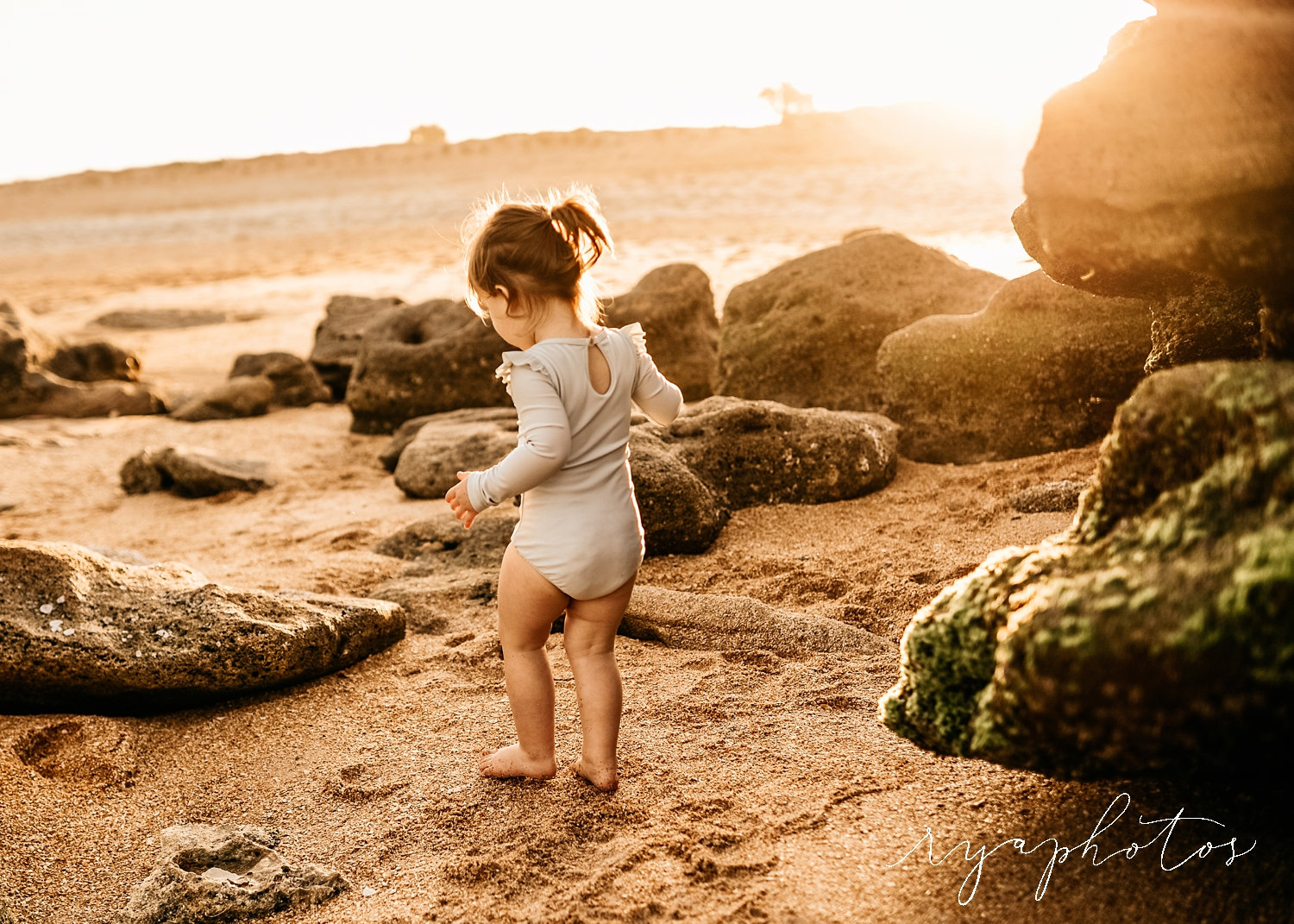 toddler girl among the sand and rocks of a Florida beach, Ryaphotos