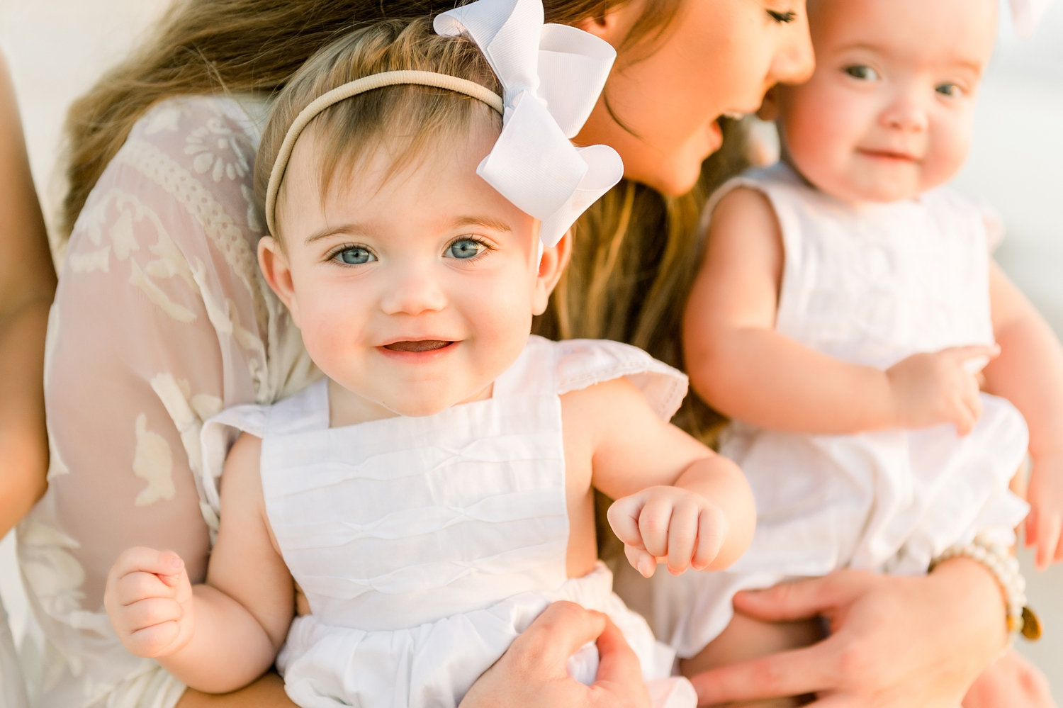 adorable twin girls in the arms of their mom, golden hour sunrise photography