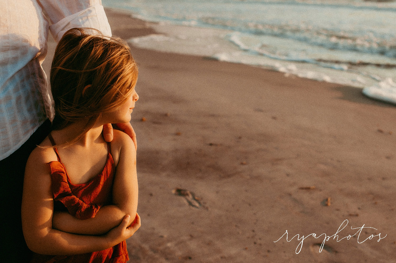 little girl in her father's arm, footprints in the sand, family beach photography, Ryaphotos
